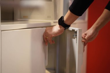 Kesilmiş görüntü, seçici odak, genç bir kadının elleri ofisteki dolabın kapısını açar ya da kapatır.