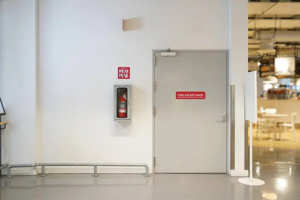 The Fire extinguisher on the wall and fire escape doors within the department store, Security system with banner If there is an emergency accident near walkway and can be clearly seen.