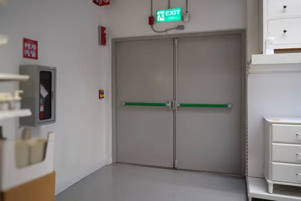 The Fire extinguisher on the wall and fire escape doors within the department store and Exit banner, Security system with banner If there is an emergency accident near walkway and can be clearly seen