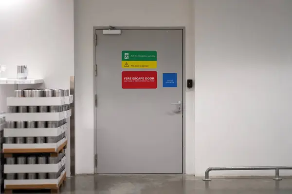 The Fire extinguisher on the wall and fire escape doors within the department store and Exit banner, Security system with banner If there is an emergency accident near walkway and can be clearly seen.