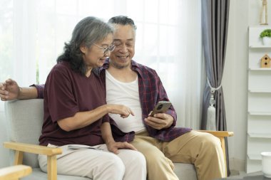Kanepede akıllı telefonları olan hoş bir çift boş zamanlarını sosyal ağlarda geçirir, video izler, güzel bir eşle eş selfie 'si izler ve mutlu bir şekilde güler ve sohbet ederler.