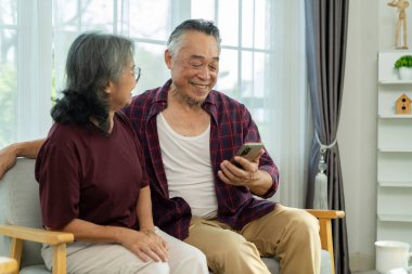 Kanepede akıllı telefonları olan hoş bir çift boş zamanlarını sosyal ağlarda geçirir, video izler, güzel bir eşle eş selfie 'si izler ve mutlu bir şekilde güler ve sohbet ederler.