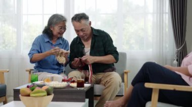 Emekliliğin tadını çıkaran, evde örgü ören Asyalı yaşlı bir çift. Kadınlar erkeklere yeni hobiler öğretiyor. Konforlu oturma odasında aktif yaşlanma ve arkadaşlık gösteriliyor..