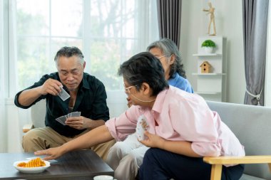 Emekli Asyalı arkadaşlar birbirlerini kağıt oynamaya davet ediyorlar. Bir erkek oyunu kazandığını sanır, ama bayan arkadaşının kartları daha iyidir ve kazanır. Oturma odalarında sosyalleşiyorlar.