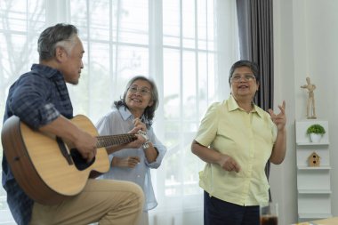 Güzel bir grup partisi, yaşlı arkadaşlara oturma odasında eğlendiklerini göstermek. Biri gitar çalarken diğerleri şarkı söyler ve dans eder, müzik ve arkadaşlığın tatlı anlarını paylaşır.