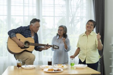 Güzel bir grup partisi, yaşlı arkadaşlara oturma odasında eğlendiklerini göstermek. Biri gitar çalarken diğerleri şarkı söyler ve dans eder, müzik ve arkadaşlığın tatlı anlarını paylaşır.