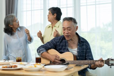 Güzel bir grup partisi, yaşlı arkadaşlara oturma odasında eğlendiklerini göstermek. Biri gitar çalarken diğerleri şarkı söyler ve dans eder, müzik ve arkadaşlığın tatlı anlarını paylaşır.