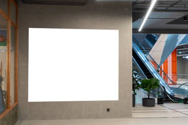 Alışveriş merkezindeki yürüyen merdivenin yanındaki duvara boş reklam panosu reklamları, reklam, poster ya da herhangi bir promosyon koymak için boş alan, hem dijital hem de basılı sunumlar için