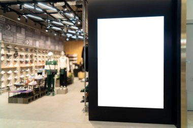Spor ayakkabıları mağazasının önündeki siyah arkaplan üzerine boş dikey reklam panosu reklamı, reklamlar için boş alan veya alışveriş merkezindeki promosyon alanı 