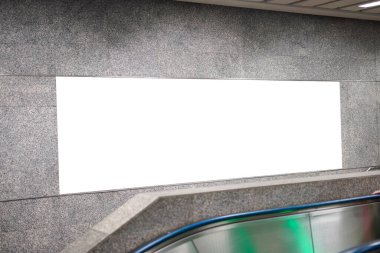 Yürüyen merdivenin yanındaki duvara ve metro istasyonundaki koridora boş ilan panosu ya da halka açık alandaki bilgi için boş alan