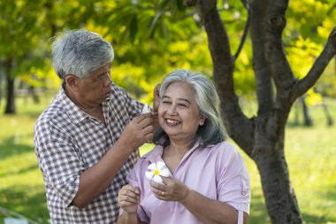 Asyalı yaşlı bir çiftin halka açık bir parkta kaliteli zaman geçirmesi ne hoş. Koca, narin bir çiçeğe sarılıp, aşkını paylaşan kadının yüzüne şefkatle dokunur.. 