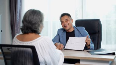  Profesyonel İşadamı belgeyi, belgeyi muhtemelen rapor veya grafiği, dikkatle dinleyen, finansal danışmanlık yapan veya modern ofiste profesyonel hizmetleri olan kadın müşteriye açıklar