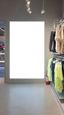 Çağdaş spor giyim mağazasında reklam veya tanıtım afişi için hazırlanmış, modern iç tasarım ve ürün düzenlemelerini ön plana çıkaran boş reklam panosu modeli sergilendi.