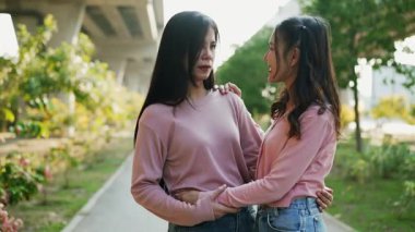 İki genç Asyalı kadın parkta bankta oturuyor, biri diğerinin duygusal görünmesine yardım ediyor. Tartışma sırasında el ele tutuşuyorlar. Bir destek ve dostluk anı..