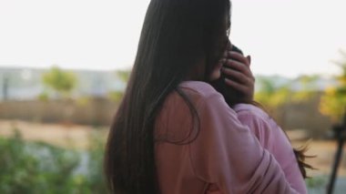 İki genç Asyalı kadın parkta bankta oturuyor, biri diğerinin duygusal görünmesine yardım ediyor. Tartışma sırasında el ele tutuşuyorlar. Bir destek ve dostluk anı..