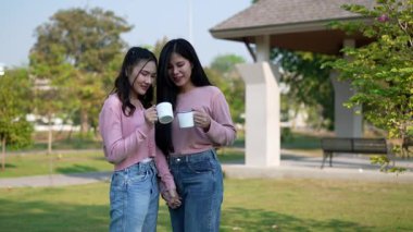 İki genç Asyalı kadın parkta bankta oturuyor, biri diğerinin duygusal görünmesine yardım ediyor. Tartışma sırasında el ele tutuşuyorlar. Bir destek ve dostluk anı..