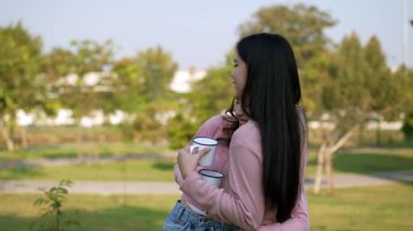 İki genç Asyalı kadın parkta bankta oturuyor, biri diğerinin duygusal görünmesine yardım ediyor. Tartışma sırasında el ele tutuşuyorlar. Bir destek ve dostluk anı..