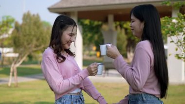 İki genç Asyalı kadın parkta bankta oturuyor, biri diğerinin duygusal görünmesine yardım ediyor. Tartışma sırasında el ele tutuşuyorlar. Bir destek ve dostluk anı..