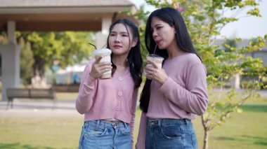 İki genç Asyalı kadın parkta bankta oturuyor, biri diğerinin duygusal görünmesine yardım ediyor. Tartışma sırasında el ele tutuşuyorlar. Bir destek ve dostluk anı..