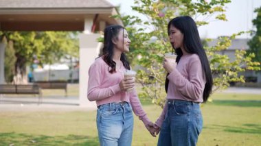 İki genç Asyalı kadın parkta bankta oturuyor, biri diğerinin duygusal görünmesine yardım ediyor. Tartışma sırasında el ele tutuşuyorlar. Bir destek ve dostluk anı..