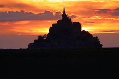 Romantik gün batımı gökyüzü ve Kuzey Fransa 'daki Mont Saint Michel Manastırı' nın karanlık silueti