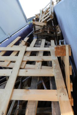 Malzemelerin toplanması için konteynırda bulunan ahşap paletler belediye geri dönüşüm merkezinde geri dönüştürülecek