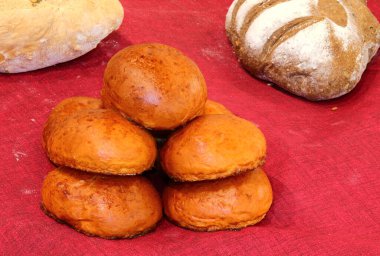 Fırıncı tarafından yeni pişirilmiş un ve tohumlarla yapılmış bir sürü somun ekmek.