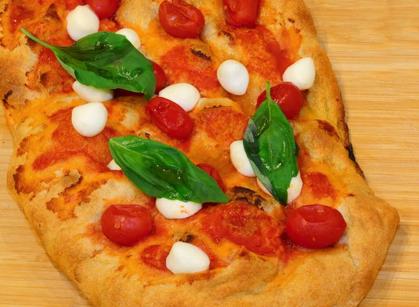 pizza or Italian focaccia cooked in a wood oven with cherry tomatoes  and buffalo mozzarella cheese and basil