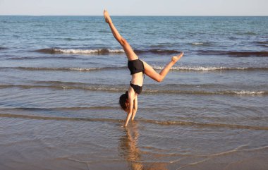 Zayıf atletik kız yazın jimnastik yapıyor.