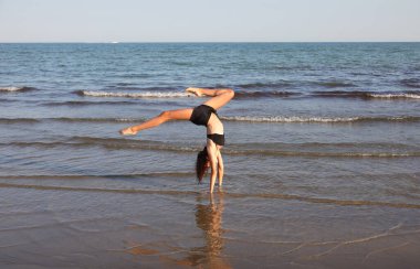 Zayıf atletik kız yazın jimnastik yapıyor.