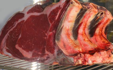 Kasap dükkanının endüstriyel dondurucusunda büyük bir parça çiğ kırmızı et var.