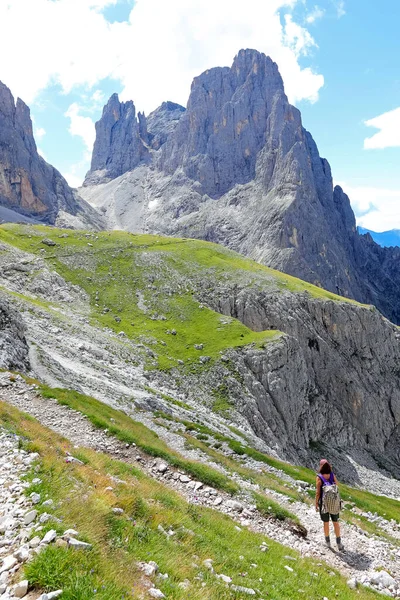 年轻女子背着背包走在阿尔卑斯山的石子路上 — 图库照片