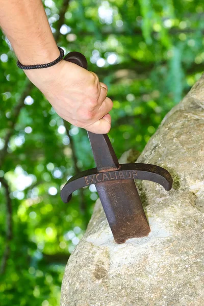 Ręka Młodego Człowieka Który Siłą Próbuje Wyciągnąć Miecz Excalibur Utknął — Zdjęcie stockowe