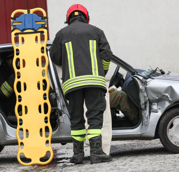 Пожарный Желтыми Носилками Помогает Раненым Разбитой Машине После Дтп — стоковое фото