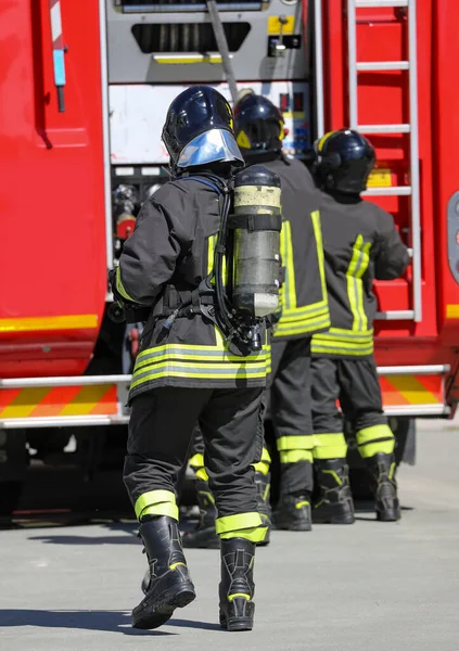 在紧急情况下 背景中装有氧气罐和消防车的消防员 — 图库照片