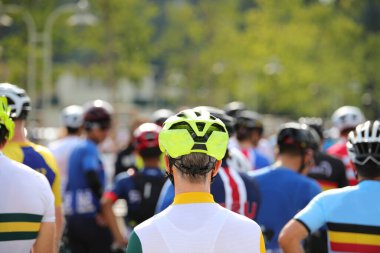 Bisiklet yarışından önce kask takan bisikletçi ve diğer bisikletçiler