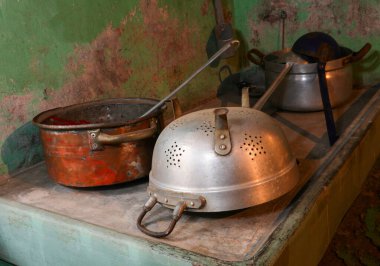 ancient copper pot and aluminum colander of a rural house without people