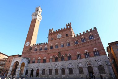 High tower called TORRE DEL MANGIA and the town hall of Siena in the main square of the city in Italy