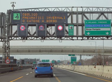 Wide Signal in the Motorway with text that means obligation winter equiment or snow chains in Italian Language