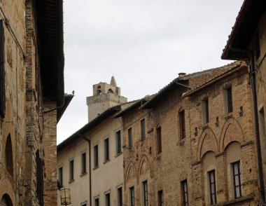 Ancient houses and the medieval tower in the ancient village of San Gimignano in the Tuscany region in central Italy