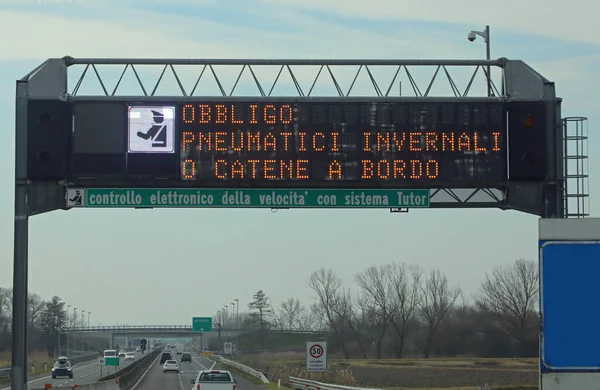Wide Signal in the Motorway with text that means obligation winter equiment and Speed Check in Italian Language
