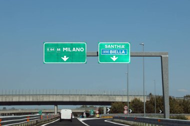 Wide Road signal with italian place such as Milan Santhia and Biella