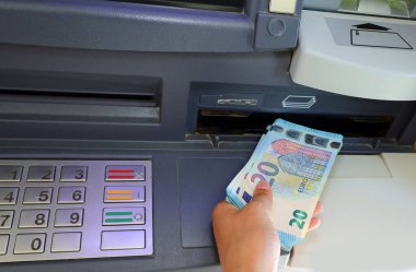 human hand with many european banknotes at ATM