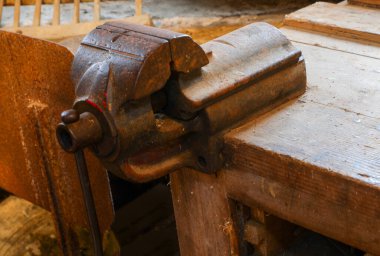 old iron vice in the workbench of an artisan carpentry
