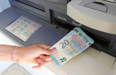 hand that takes banknotes twenty euros in the ATM branch of the European Bank