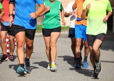 many runners during the marathon on the city streets run in sneakers