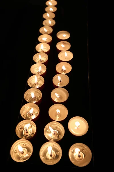 在教堂内举行的信众弥撒期间 点燃了点燃的祈祷的蜡烛 — 图库照片