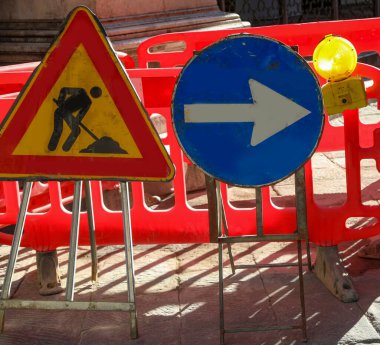 Şehirdeki yol inşaatı ve büyük oklu tabelalar.