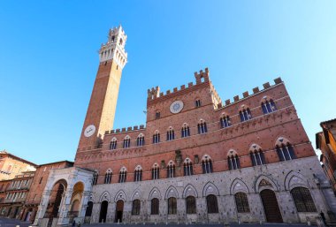 High tower called TORRE DEL MANGIA and the town hall of Siena in the main square of the city in Italy