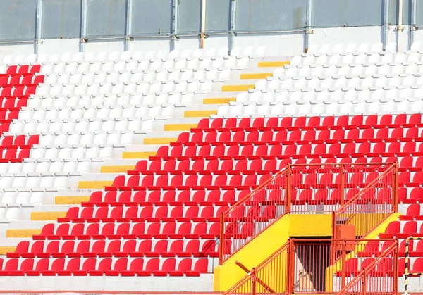 スタジアムの多くの空の赤と白の座席は人や緊急脱出なしで立っています — ストック写真